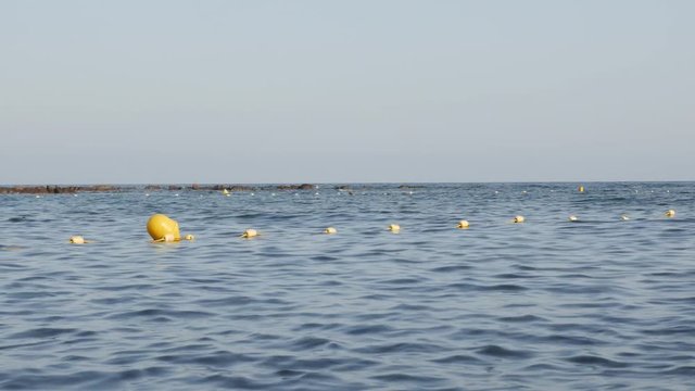 Blue sea and yellow buoys as swim area signs footage - Close-up swimming zone border signs on French coast video 