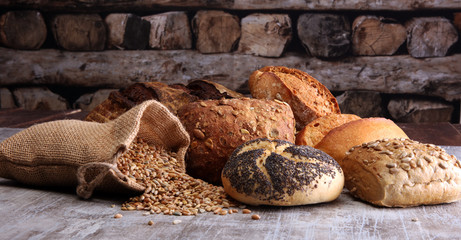 Different kinds of bread and bread rolls on board. Kitchen or bakery poster design.