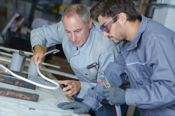 engineer teaching apprentice to use tig welding machine - obrazy, fototapety, plakaty