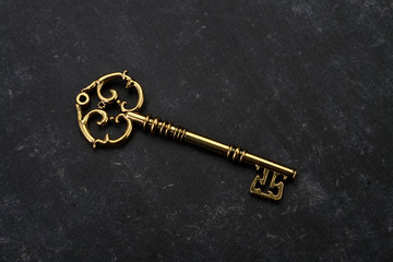 Golden Key on Black Grunge Background