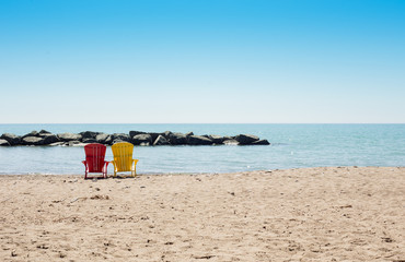 beach scene with two colorful adirondack chairs