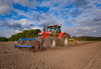 Ackerbau - roter Traktor bei der Herbsteinsaat 