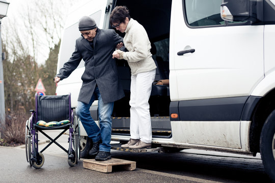 Nurse Helping Senior Man Exit A Van