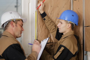 builders insulating wooden house with mineral rock wool