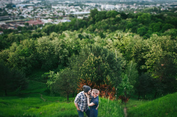 Fototapeta na wymiar traveler couple in casual clothes gently hugging while standing near tree