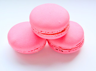 Three pink almond  French  cookies  macaroons on a white background isolated.selective focus, toned image. Food, dessert,beautiful gentle composition.