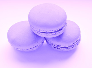 Three lilac almond French cookies macaroons on a white background isolated.selective focus, toned image. Food, dessert,beautiful gentle composition