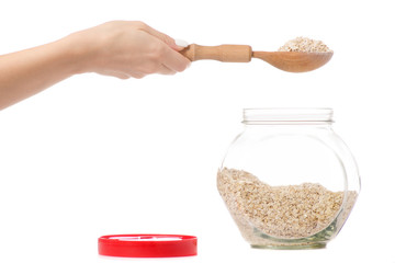 Female hand capacity with a lid of flakes of oats and a spoon