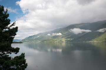 Fototapeta na wymiar Clouds and water view on the narrowest fjord in Norway