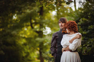groom and bride in white wedding dress enjoying in green forest