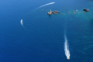 view of boats sailing on the sea, around the rocks