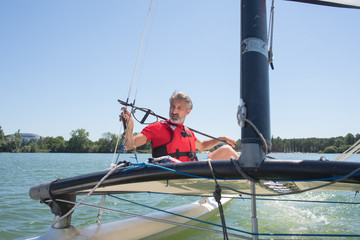 Naklejka premium man sailing with sails out on a sunny day