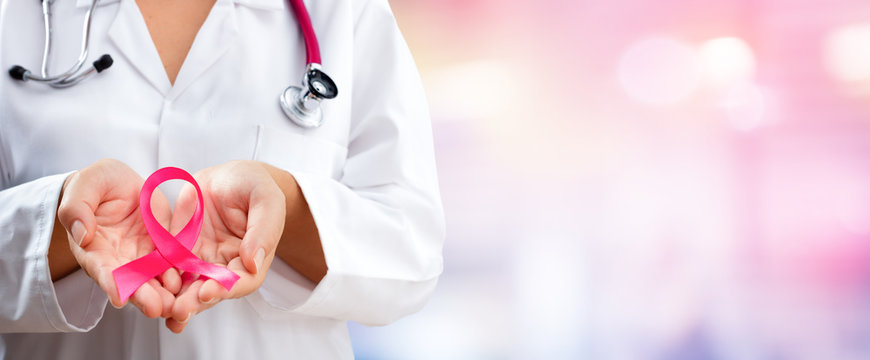Doctor Hands Holding Pink Cancer Awareness Ribbon
