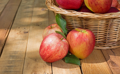 Red Apples and Basket on a Rustic Wooden Surface
