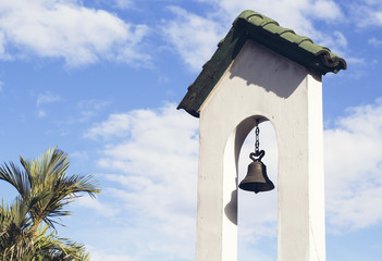 Church bell on church tower on blue sky background. Catholic church building.