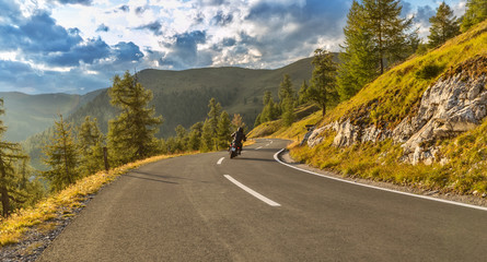 Naklejka premium Motorcycle driver riding in Alpine highway. Outdoor photography