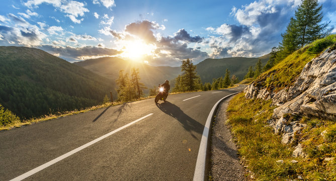 Motorcycle driver riding in Alpine highway. Outdoor photography