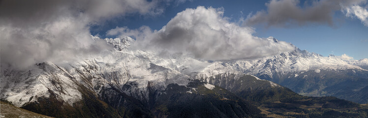 Fototapeta premium landscape, snow-capped peaks of the mountains of Svaneti in the clouds view of the valley, Svaneti, Georgia