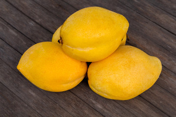 Whole yellow mango on wooden background. Bunch of tropical fruits.