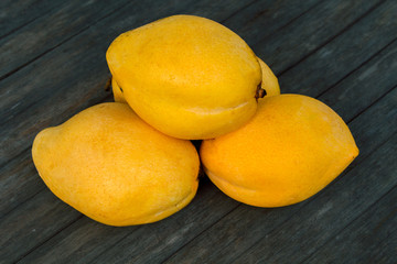 Yellow mango on wooden table background. Bunch of tropical fruits.