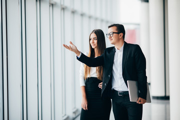 business man and business woman discusing future plans and working with new start up project in modern office in panoramic windows