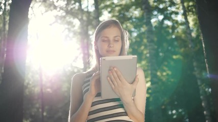 closeup of happy woman student girl using tablet pc in the park after university lessons - Powered by Adobe