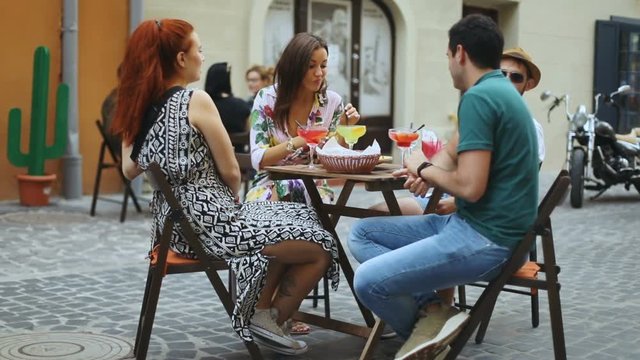 Friends concept - moving portrait of young friends chill on the city urban street in cafe, youth boys girls chat enertainment chill plans business journey trip tourist, slow motion shot