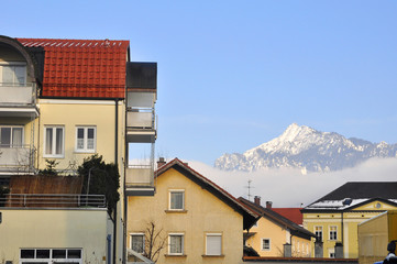 Yellow houses with a mountain in the background.