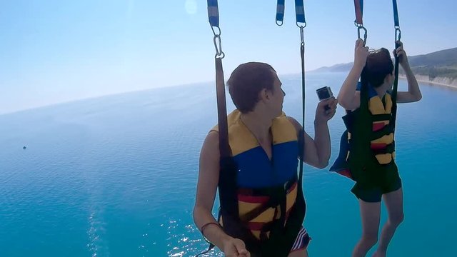 paragliding and parasailing lifestyle. man and ocean boy are flying on a parachute over the sea. Extreme sport first-person view