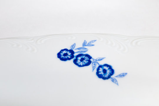 Vintage porcelain dish close up. Beautiful blue flowers detail.