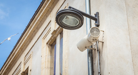 black city lamp post and loudspeakers hanging on a wall