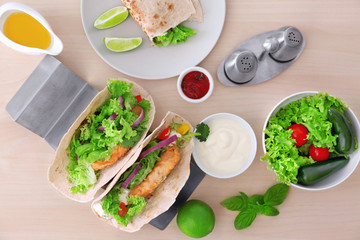 Composition with delicious fish tacos on wooden table
