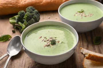 Bowl with delicious broccoli soup on table