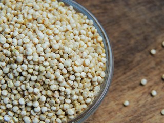 Organic quinoa super grain in glass bowl on wooden dark background.