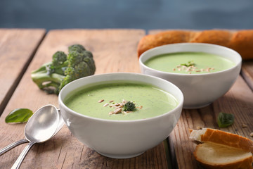 Bowl with delicious broccoli soup on table