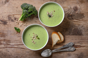 Composition with delicious broccoli soup on wooden background