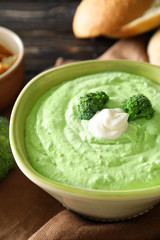 Bowl with tasty broccoli soup on table