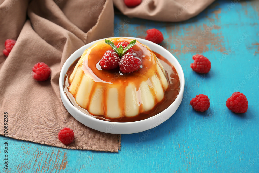 Wall mural Plate of delicious vanilla pudding with chocolate syrup on table