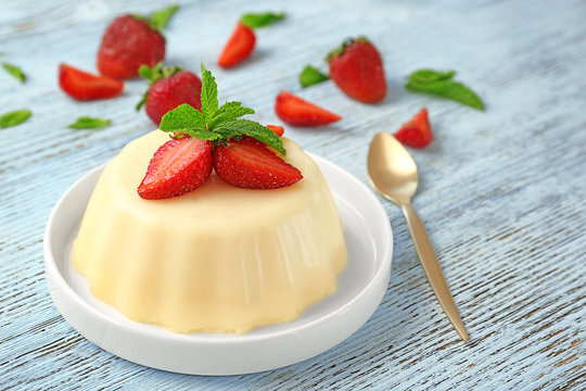 Plate with delicious vanilla pudding on table