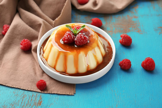Plate of delicious vanilla pudding with chocolate syrup on table