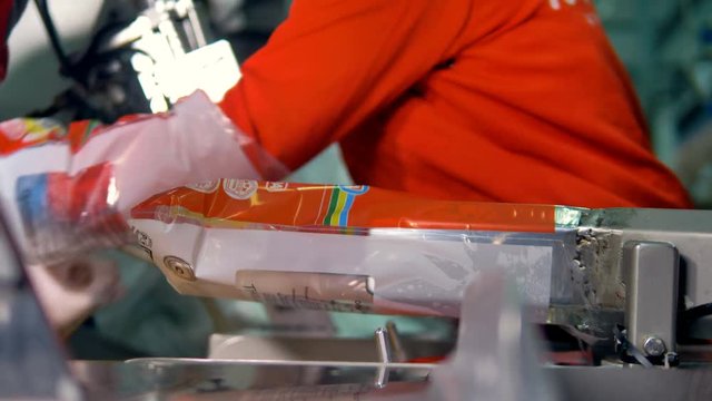 Workers hands operate a partially manual chicken packing process at food factory. 4K.