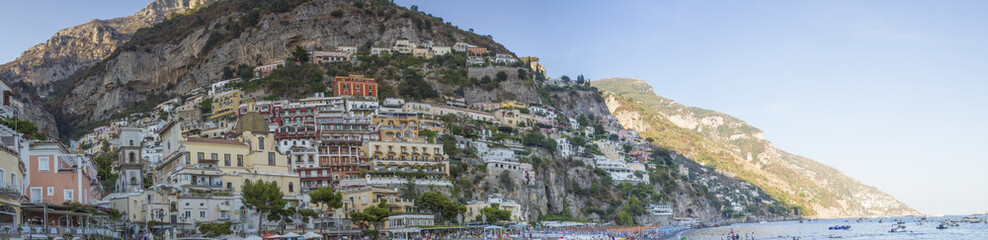 Fototapeta na wymiar Vista panoramica del borgo di Positano, famosa località turistica e balneare in costiera Amalfitana. Il paese è costruito a picco sul mare con la mantagna dietro. Le case sono colorate.