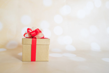 Christmas design with present in gold wrapping and red ribbon with space for text