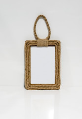 A photo frame made of hemp rope against white wall
