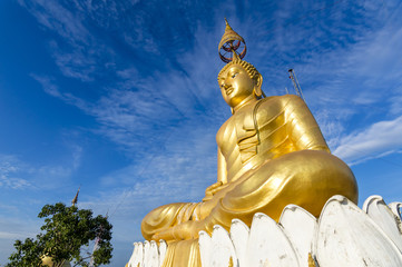 Big gold Buddha statue at the sunrise in Tiger Cave Temple in Krabi province, Thailand 