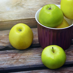 Green organic healthy apples  on wooden board.