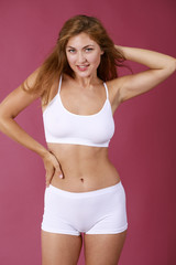 Fototapeta premium Young beautiful blonde woman in white fitness clothing