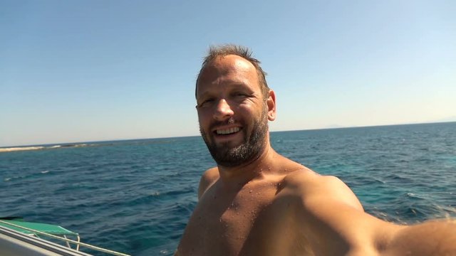 Man taking selfie photos, recording video sailing boat on sea, super slow motion 240fps
