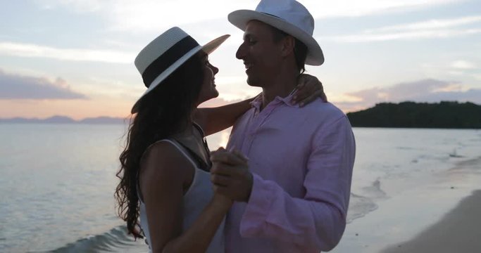 Couple Kissing On Beach At Sunset Embracing, Young Man And Woman In Love During Sea Summer Vacation Happy Tourists Slow Motion 60