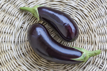 Fresh eggplants on a mat, close-up from above